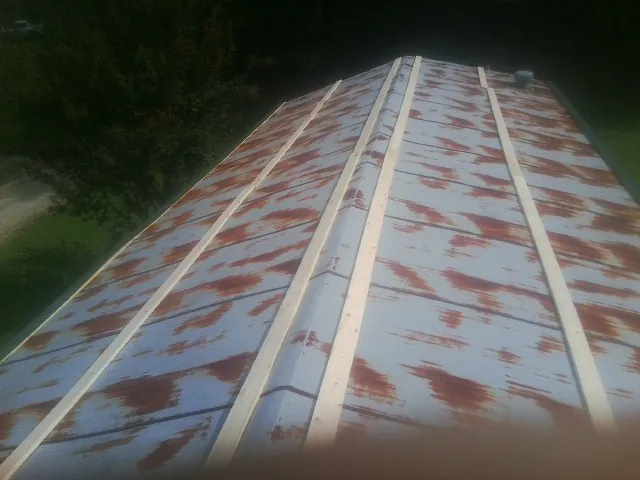 Rusted metal roof panels with new wood purlins before replacement — Storm Damage Roof Repair in Latimer by Roofing Brothers