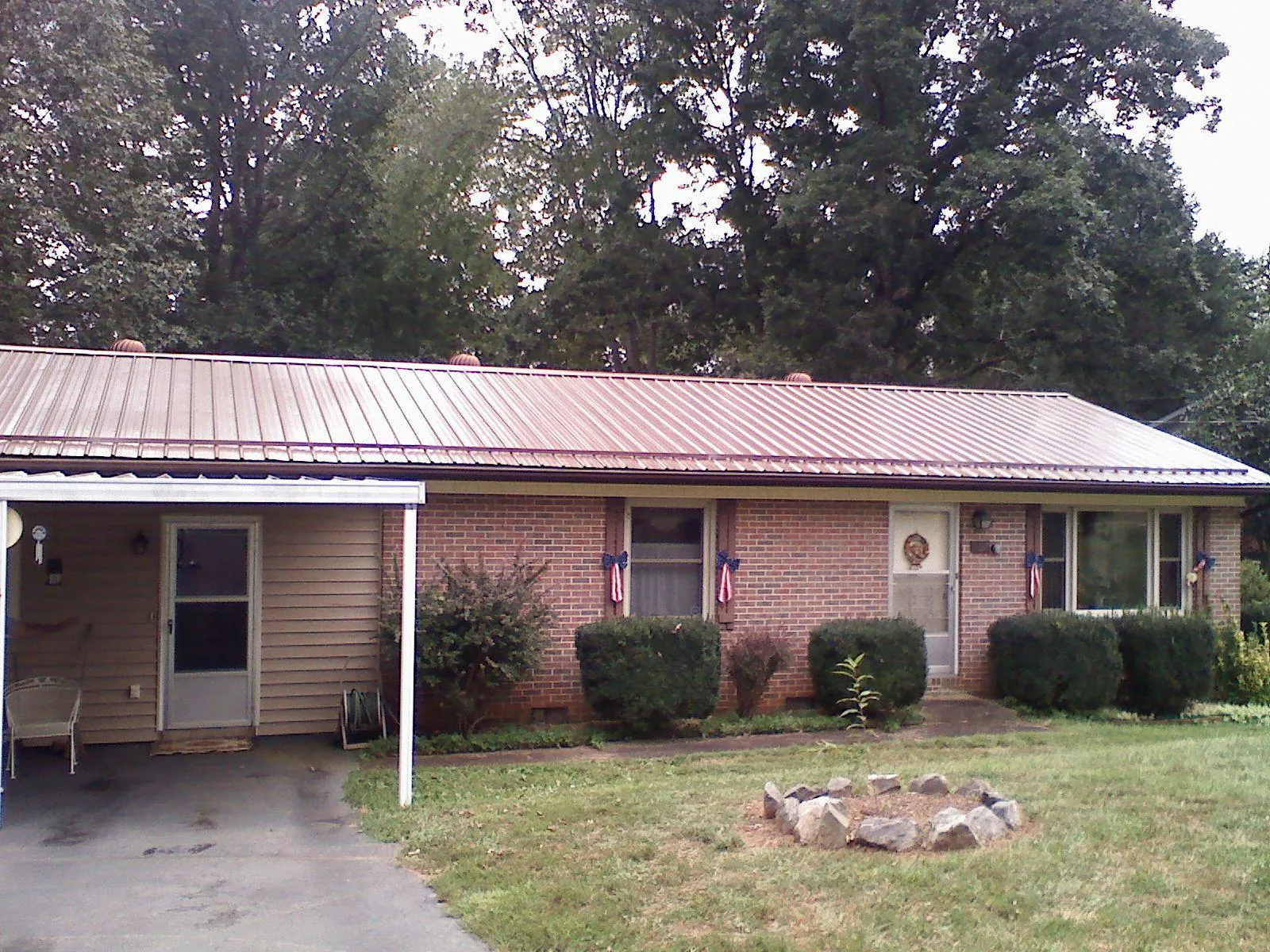 Bronze metal roof and carport on a brick ranch home — Roof Repair work by our crew in Latimer